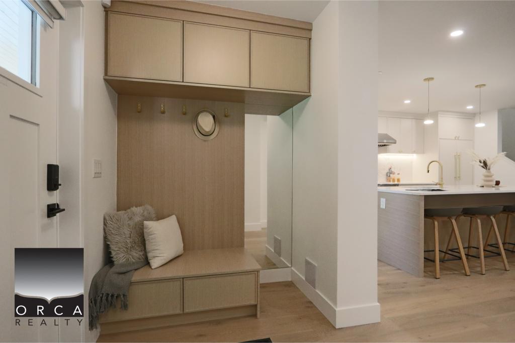 Entryway with built-in storage bench and overhead cabinets in a contemporary home.