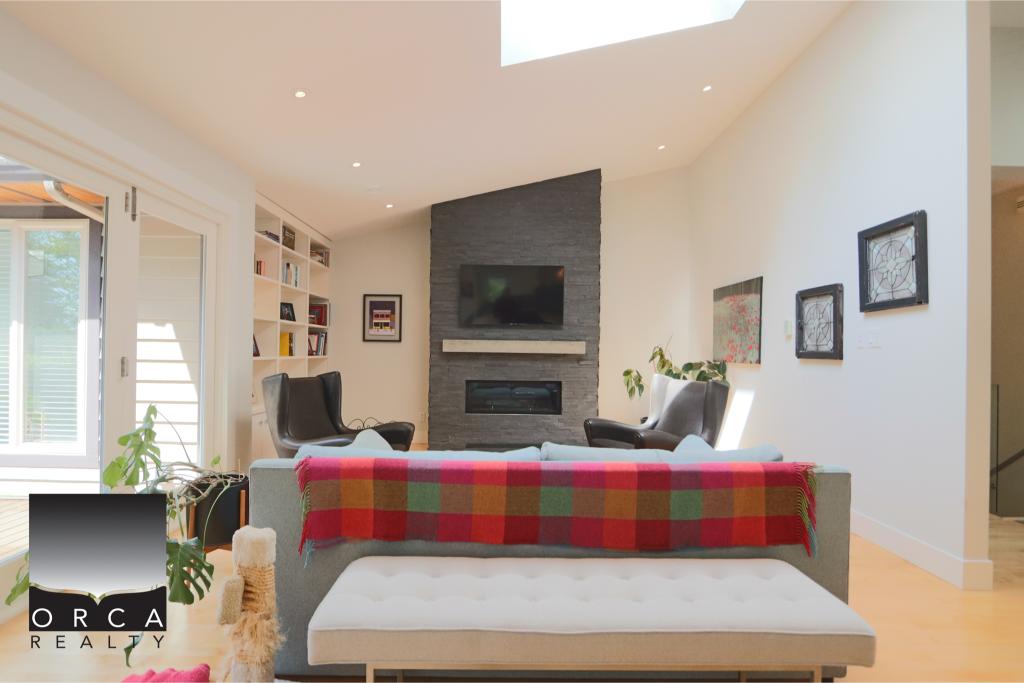 Bright and inviting living room featuring a sleek fireplace, contemporary furniture, and abundant natural light, perfect for relaxing or entertaining in a stylish home.