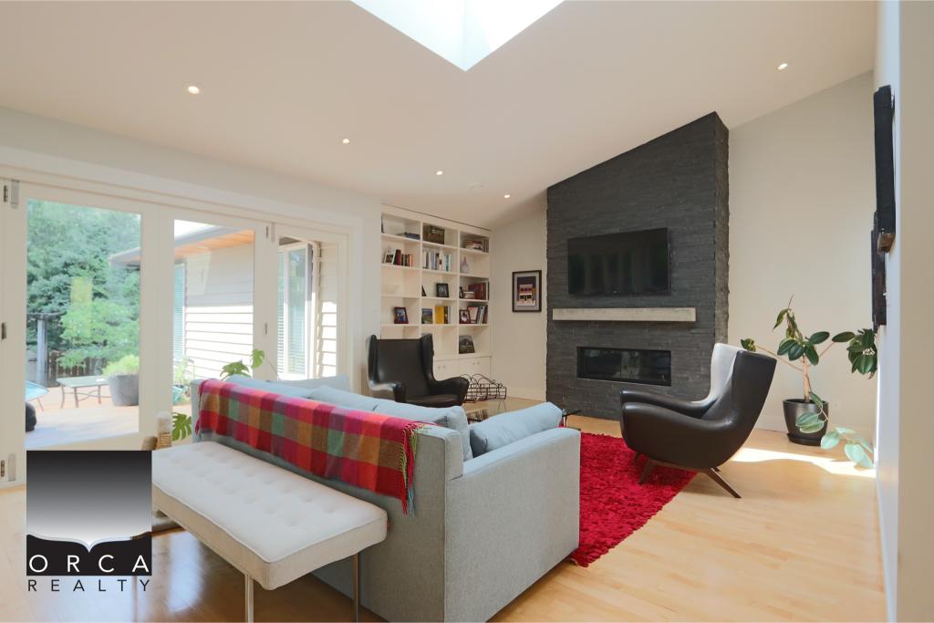 Spacious living room featuring a sleek fireplace, contemporary furniture, and large windows with natural light. Perfect for relaxing or entertaining in a stylish, comfortable setting.