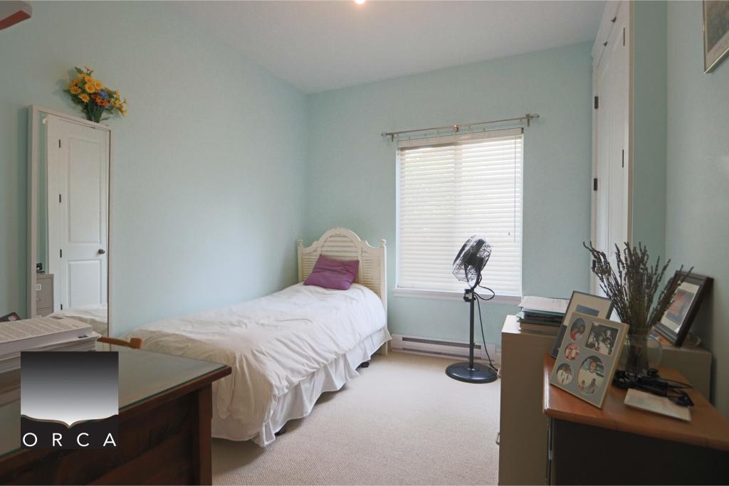 Bright bedroom with a single bed, window with blinds, and a fan.