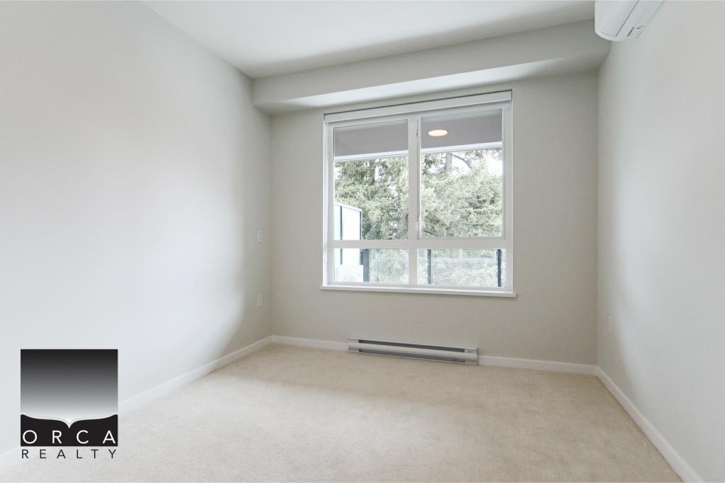 Bright, empty bedroom with large window and neutral decor at 613-629 Cottonwood Avenue, Coquitlam.