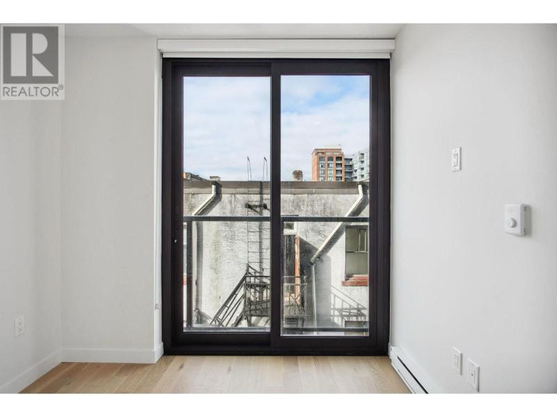 Sliding glass door leading to a balcony with cityscape view in Vancouver, BC.