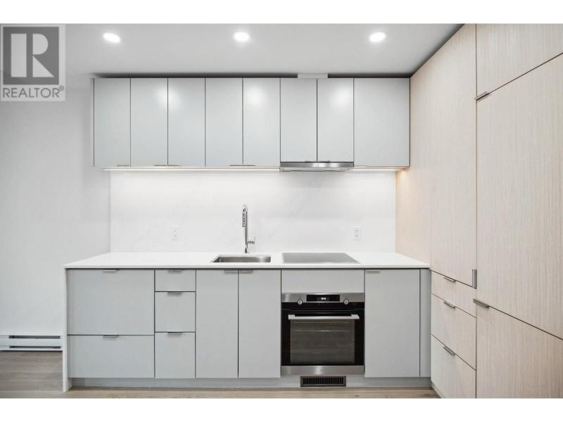 Contemporary kitchen with white cabinets, built-in oven, and minimalist design in Vancouver property.