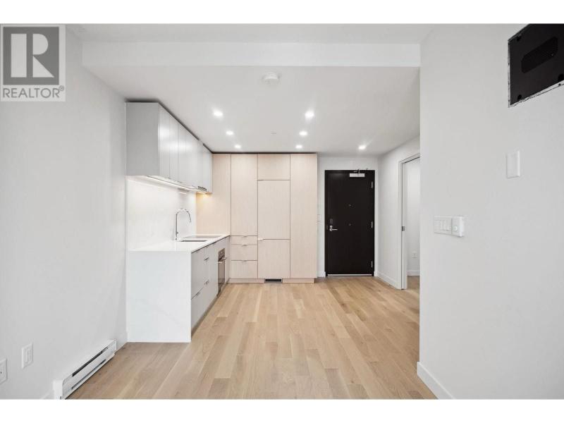 Spacious and modern interior of a Vancouver apartment with white walls, wooden flooring, and minimalist kitchen design.