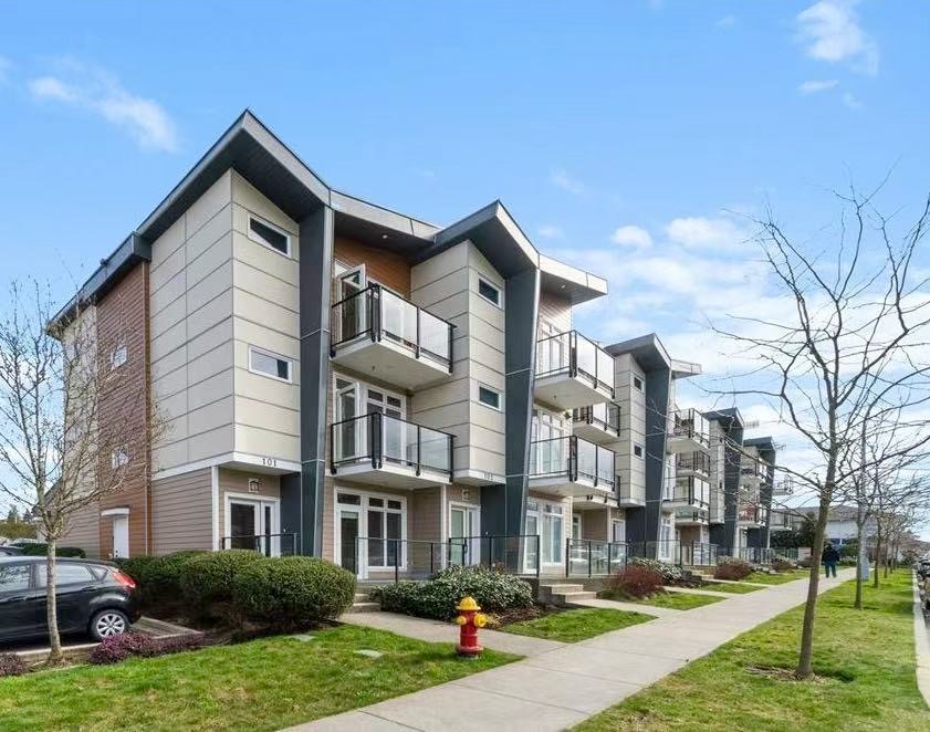 Contemporary multi-unit apartment complex in Nanaimo with balconies, landscaped surroundings, and clear blue sky.
