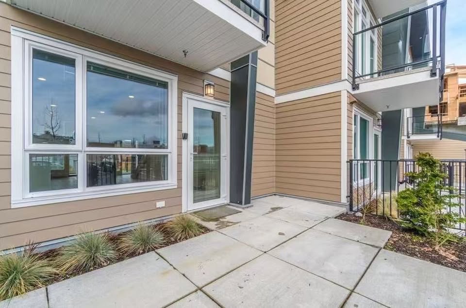Contemporary condo exterior in Nanaimo with large windows, balcony, and landscaped front yard, ideal for urban living.