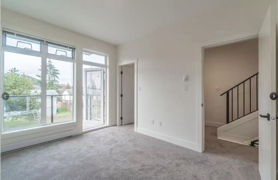 Spacious living room with large windows and neutral decor in a Nanaimo property listed by Orca Realty Inc.