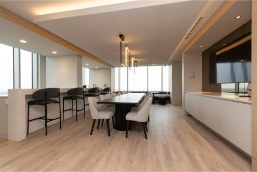 Modern interior of a Coquitlam condo with a dining area and large windows offering city views.