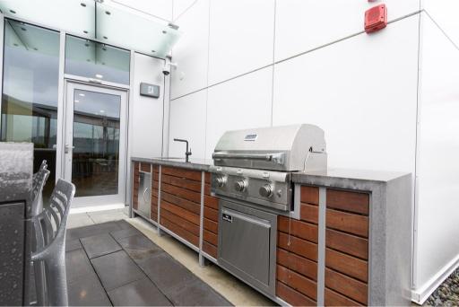 Modern outdoor kitchen with stainless steel grill and wooden cabinetry at 1409-567 Emerson St. Coquitlam.