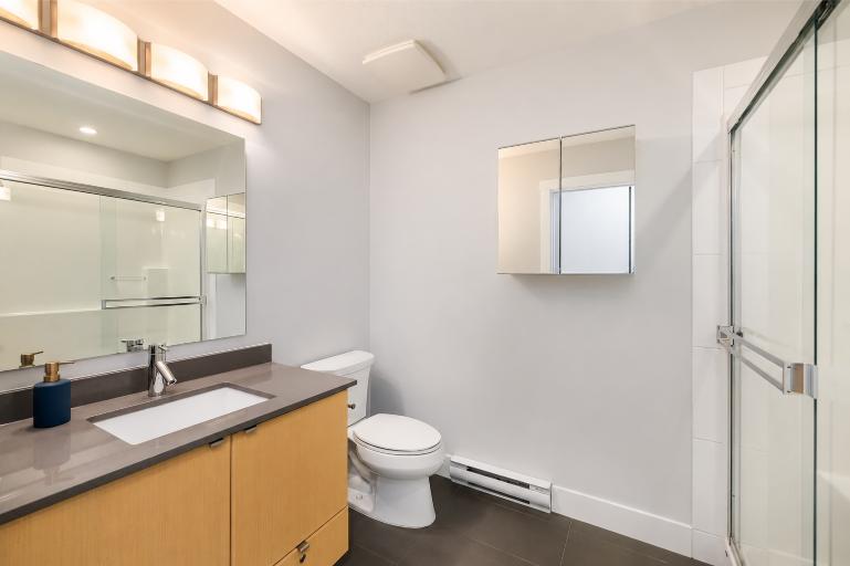 Contemporary bathroom with vanity, toilet, and shower in North Vancouver property.
