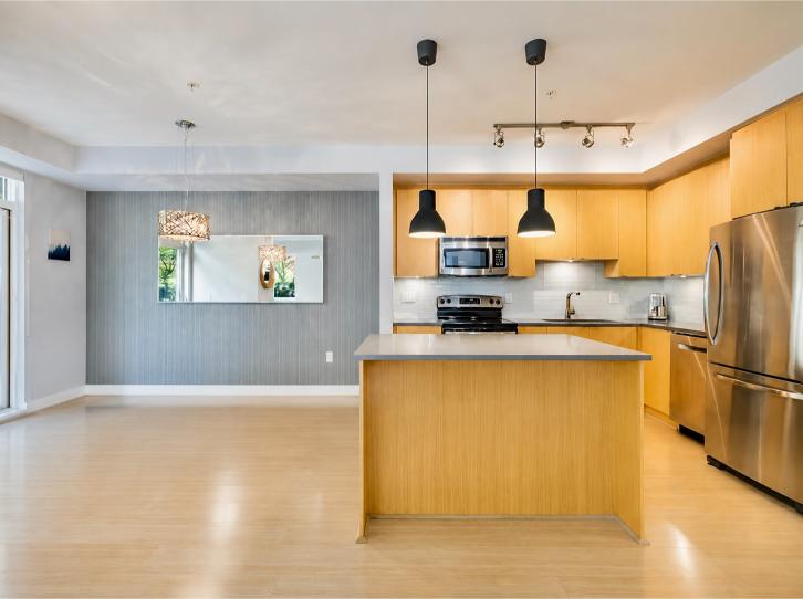 Spacious modern kitchen with wooden cabinets, stainless steel appliances, and a central island in a North Vancouver property.