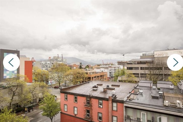 View of Vancouver cityscape showing residential buildings, trees, and cloudy sky, captured from a higher vantage point.