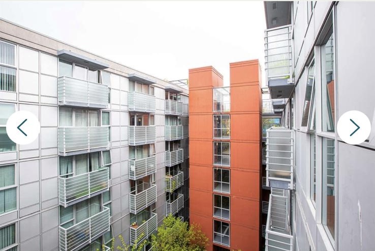 Contemporary apartment building in Vancouver with balconies and glass railings, showcasing urban residential architecture.
