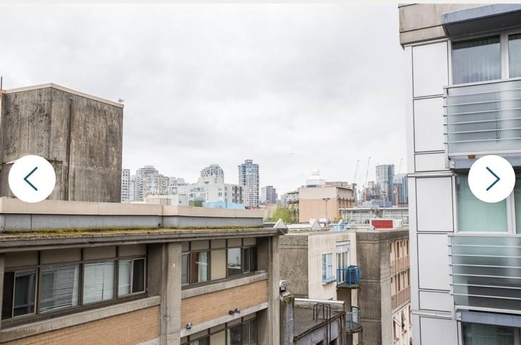 Urban cityscape view from a balcony in Vancouver, showing surrounding buildings and skyline under cloudy sky.
