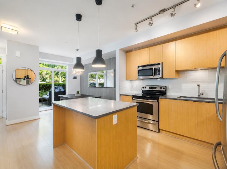 Contemporary kitchen with wooden cabinets, stainless steel appliances, and an island in a North Vancouver property.