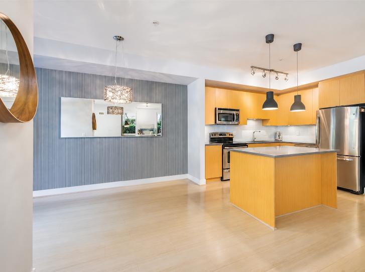 Spacious modern kitchen with wooden cabinets, stainless steel appliances, and a central island in a North Vancouver property.