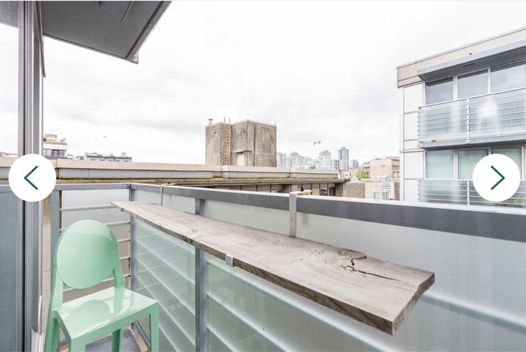 Balcony with wooden ledge and green chair overlooking Vancouver skyline from 168 Powell Street.