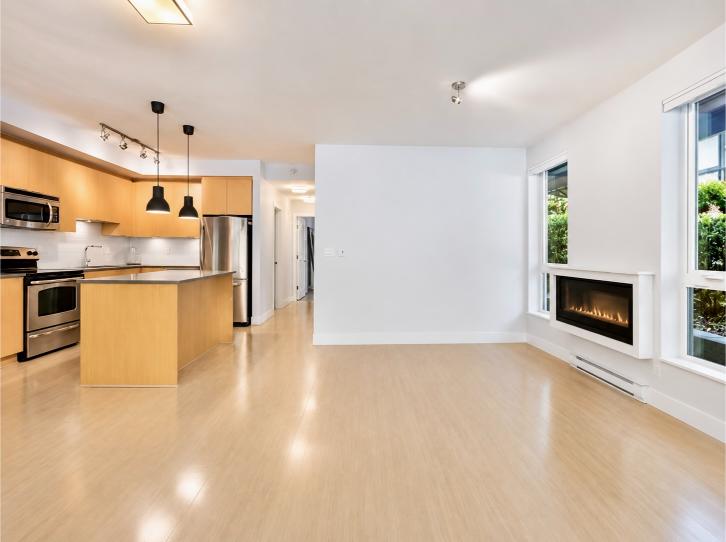 Spacious North Vancouver living room with large windows, hardwood floors, and a modern fireplace, perfect for family gatherings.